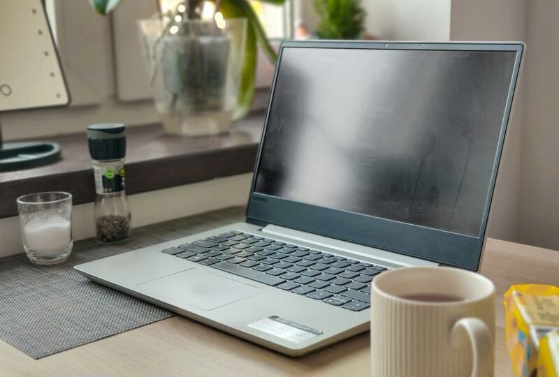 Laptop with coffee on the table with affiliate disclosure. Contact